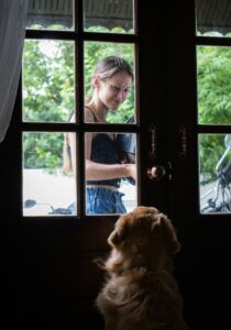 women at door and dog watching